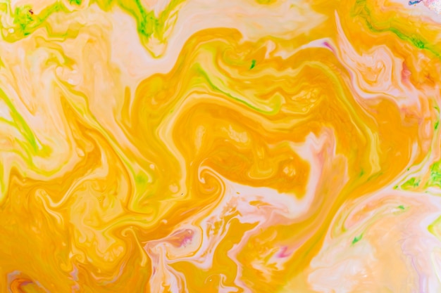 Arte fluida. astratto sfondo colorato sfocato. motivo indiano colori vivaci di giallo acido, arancio e verde