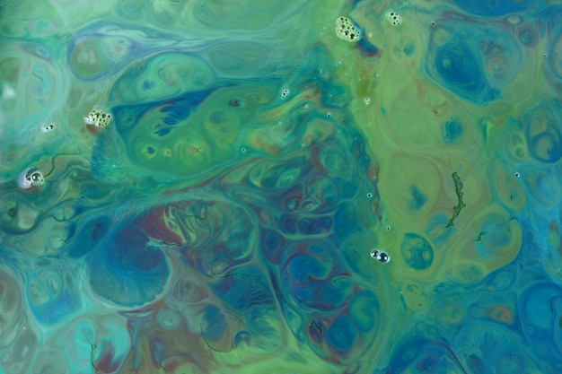 Fluid art. dark green stains of paint on the water. abstract paint background