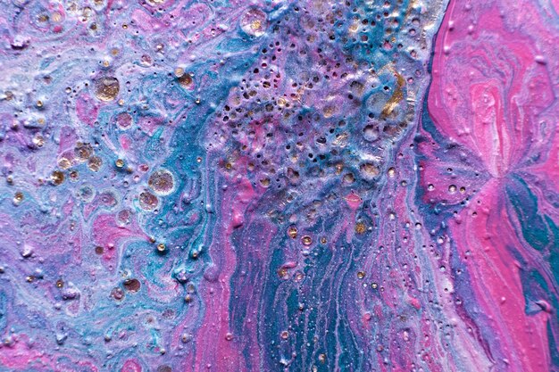 Fluid Art Embossed mixing craters and drips of pink and turquoise paint Marble effect background or texture