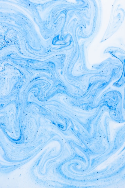 Photo fluid art with white blue color. abstract multicolored background. blue white texture. colored paint stains in liquid. fantastic iridescent colors