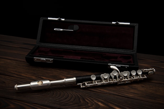 Flute with a case on a wooden background