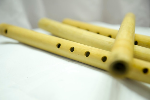 A flute with holes in it is laying on a white cloth Nepali Bamboo Flute Basuri