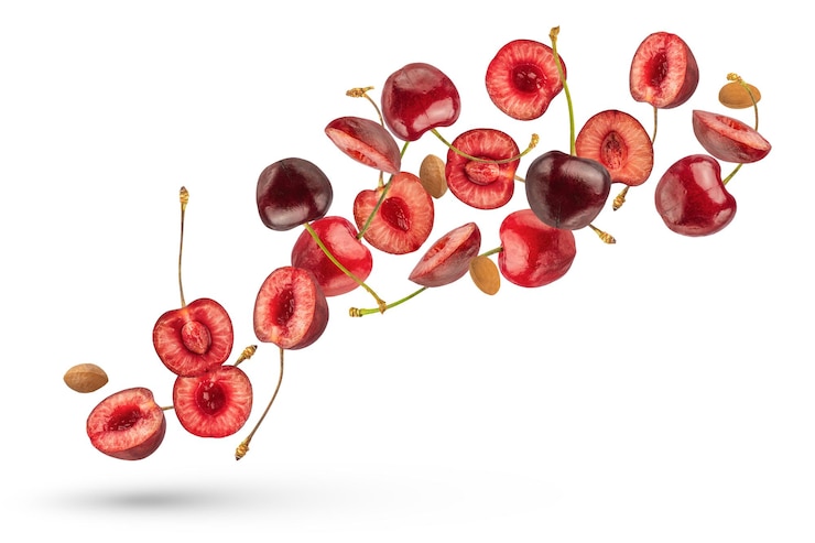 Photo flying cherry ripe cherries on a white isolated background halves and whole cherries with and without pits fly in different directions from different sides and in different sizes cherry isolate