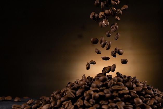 写真 テキスト用のスペースがある暗い背景に落下する茶色のコーヒー豆を飛んで