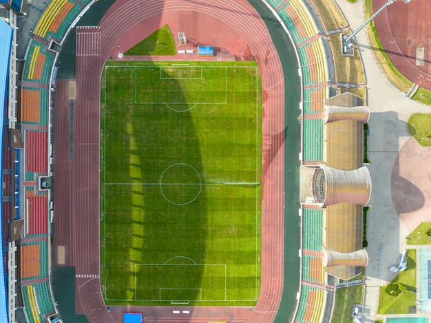 近代的なサッカー場の上空でドローンを飛ばす 手入れの行き届いたスタジアムの芝生とトレッドミルを上から見る スポーツ複合施設の灌漑と芝生管理システム