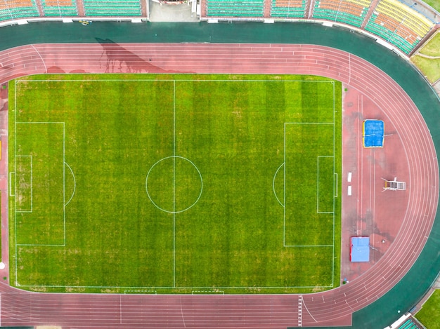 Flying a drone over a modern football field View of the manicured lawn of the stadium and the treadmill from above Irrigation and lawn care systems of the sports complex