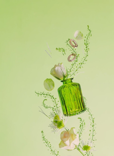 flying flowers in green glass vase on green background