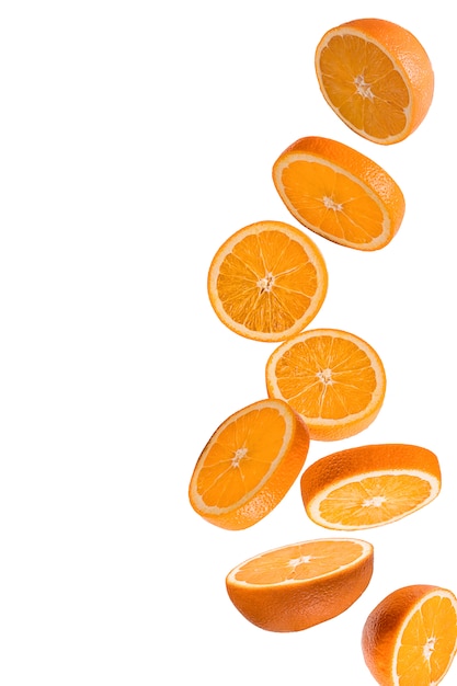 Flying fruits. Falling sliced orange fruit isolated on white