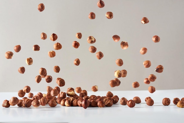 Flying hazelnut . Fresh raw hazelnut fall on a white background.