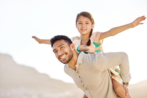 Flying high with daddy Cropped shot of a handsome young man piggybacking his daughter on the beach