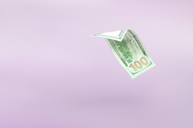 Flying one hundred dollars bills on pastel background US 100 dollar bill close up Flying money