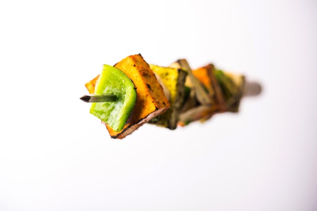 Flying Paneer Tikka isolated over white surface, selective focus