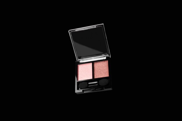 Flying pink eyeshadows isolated on black background