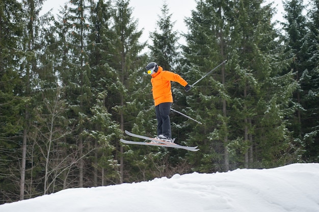 Flying skier man at jump from the slope of mountains