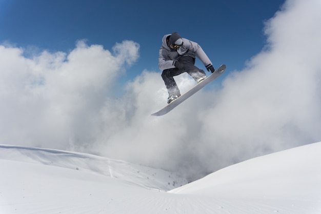 Flying snowboarder on mountains.