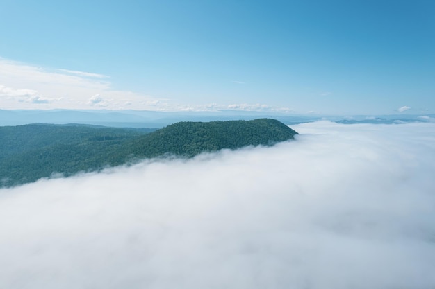 산 정상 위의 구름을 통해 비행. 높은 봉우리 멋진 아침 일출 자연 풍경