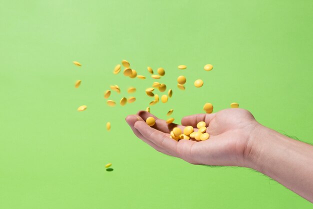 Flying yellow medicine pills from hand