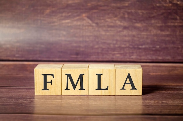 FMLA familie medisch verlof act symbool Concept woorden FMLA familie medisch verlof handelen op houten blokken op een mooie houten achtergrond