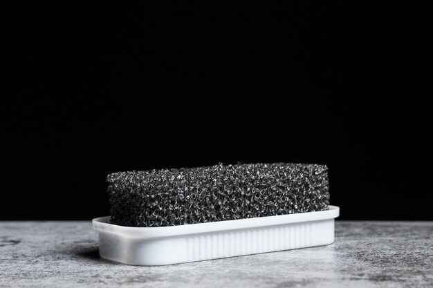 Foam sponge for suede shoes on a black background with copy space