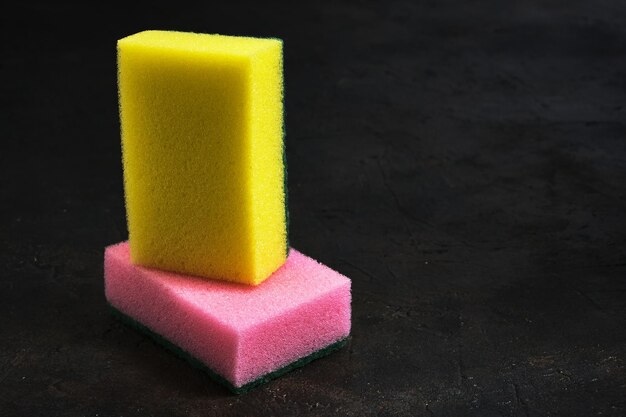 Foam sponges of different colors on a dark background.