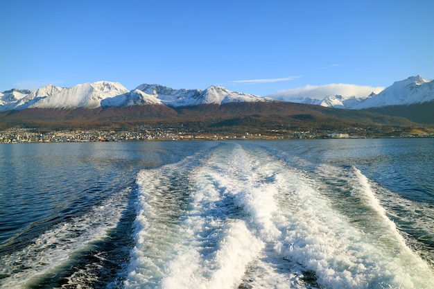 Foaming water at the cruise ship stern with Ushuaia city Tierra del Fuego Argentina