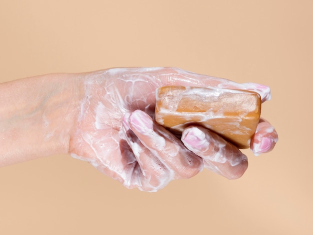 Foamy hand holding soap bar