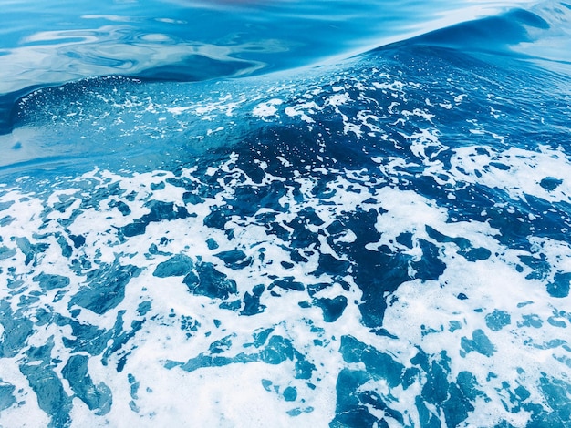 Photo foamy sea water with waves formed by boat