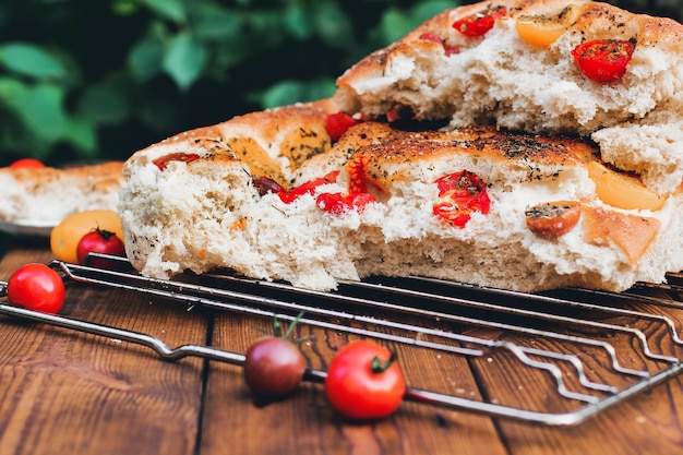 Focaccia. Italian bread. Bread with tomatoes. Homemade food. Cook at home. Fresh bread on the wire rack