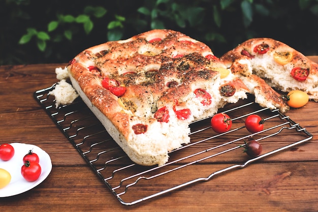 Foto focaccia. pane italiano. pane con i pomodori. cibo fatto in casa. cucina a casa. pane fresco sulla griglia