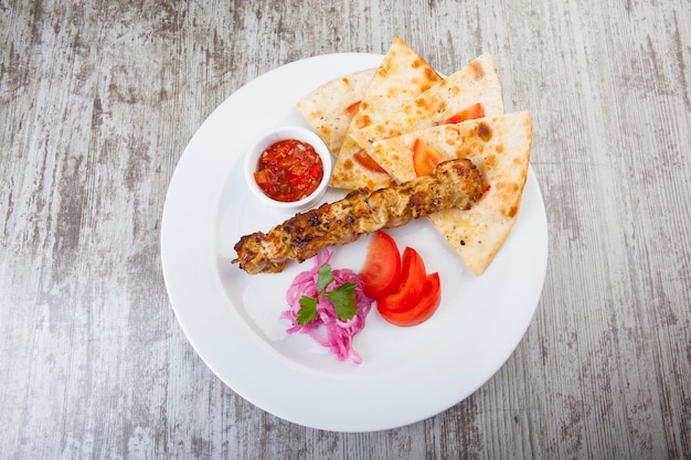 Photo focacia with kebabs and hot red sauce