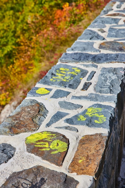 Focus along stone wall with yellow graffiti hand prints family\
memories