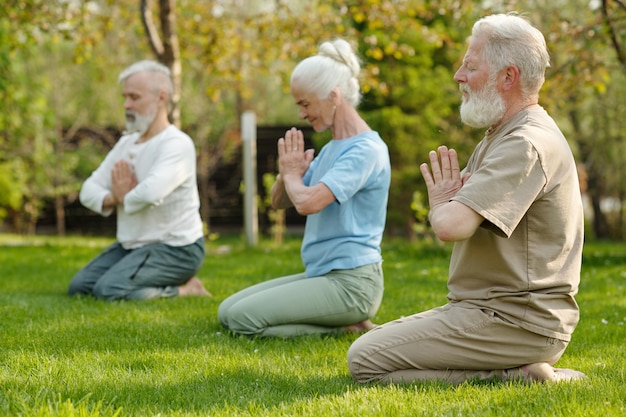 Focus on bearded senior man keeping hands put together by chest