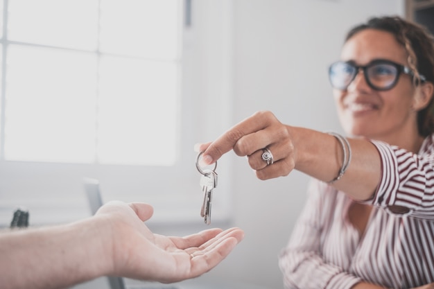 Focus on bunch of keys from house flat apartment in hand of smiling female Blurred portrait