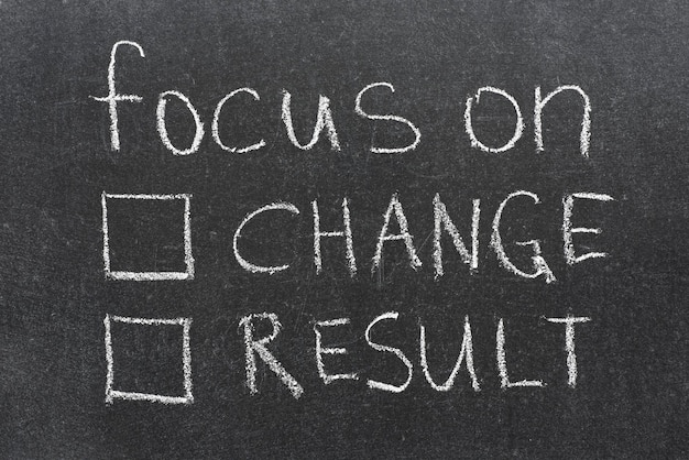 Focus on change or result phrase with two empty check-boxes handwritten on blackboard