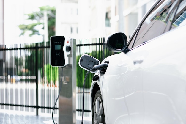 Focus closeup EV car and charger with blur background for progressive concept