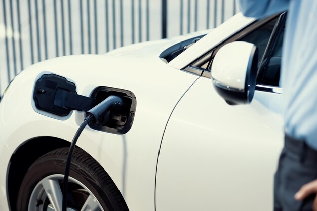 Focus closeup EV car recharge battery at public charging station