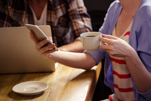 一杯のコーヒーと電話に焦点を当てる