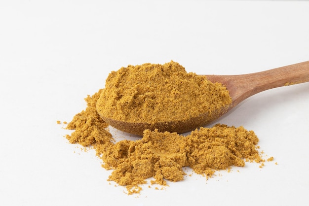 Focus on curry powder on wooden spoon