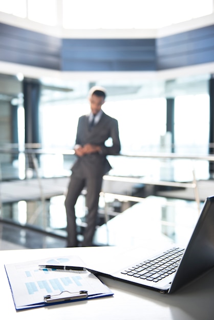 Focus on documents and laptop on the table.