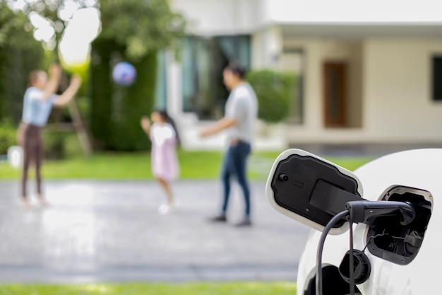 Focus EV 충전기는 진보적인 가족을 배경으로 집에서 EV 자동차를 충전합니다.