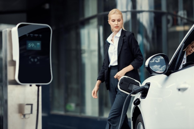 Зарядная станция Focus EV для электромобиля с размытой прогрессивной деловой женщиной