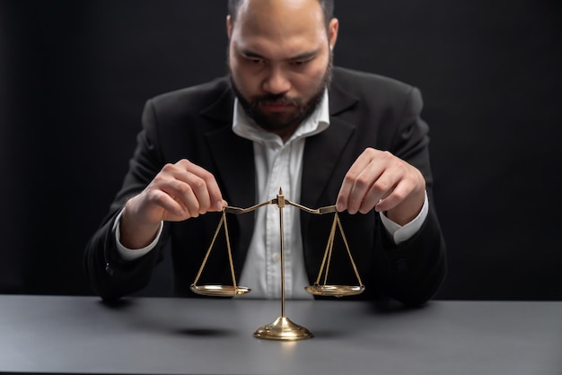 Focus gavel with blur lawyer sitting at his desk and worried equility