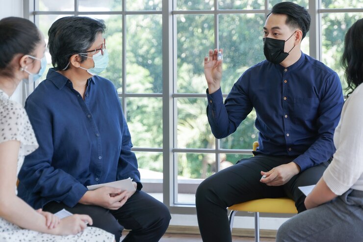 Photo 心理健康專題組由心理學家顧問 戴面罩的亞洲人開會