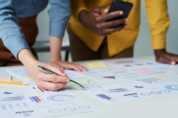 Focus on hand of female economist or accountant pointing at financial document