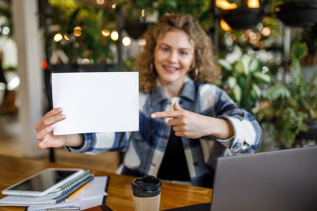 Focus of happy young woman blogger with paper