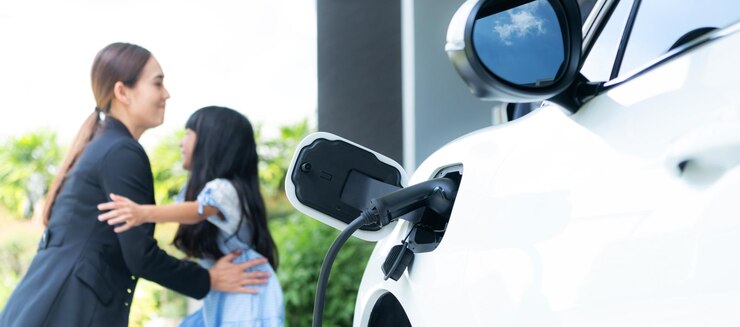 Photo バック グラウンドで ev 車のぼかしプログレッシブ ファミリーのホーム充電ステーションに焦点を当てる