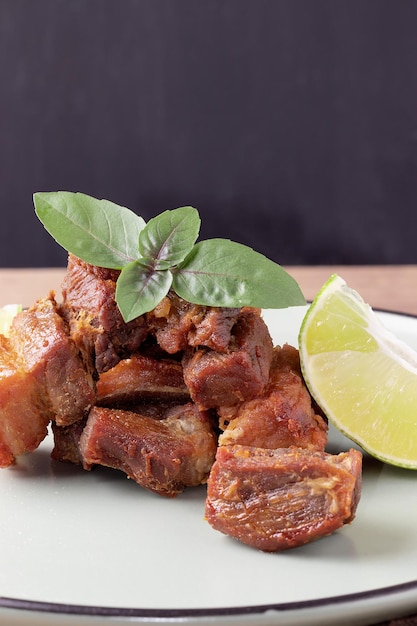 Focus on Italian pancetta, meat pork belly served with lemon.