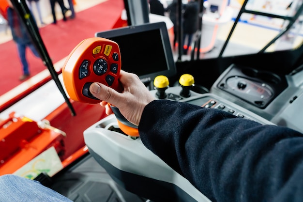 Focus on the joystick. Multifunctional lever in the control cabin of the agricultural combine.