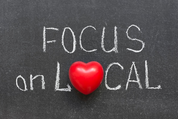 Focus on local phrase handwritten on chalkboard with heart symbol instead of O