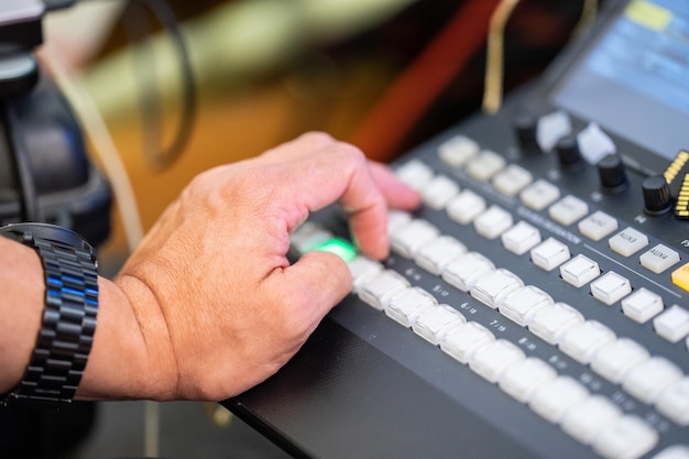 Focus on man's hand how control the livestreaming switcher board